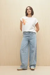 Pantalón de jean negro de corte ancho, tiro medio y cinco bolsillos.