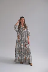 Vestido largo de corte amplio con estampado geométrico en tonos grises, marrones y blancos. Tiene cuello en V y mangas 3/4.