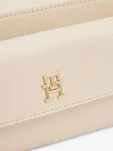 Bandolera Tommy Hilfiger color crema con logo de la marca en dorado en el frente.