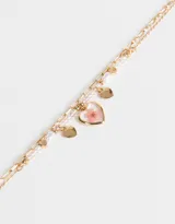 Collar corto dorado con doble cadena, una de eslabones y otra con cuentas y perlas. Incluye dijes de corazones y flores encapsuladas.