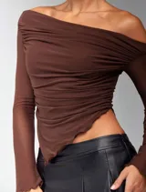 Top marrón con escote off-shoulder, mangas largas transparentes y corte asimétrico.