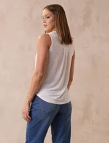 Blusa sin mangas color blanco, marca Absolutely Famous, confeccionada en seda fría. Presenta escote en V con detalle de lazo entrelazado.