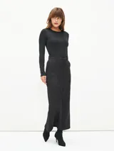 Falda midi negra de corte recto, con cintura alta, bolsillos laterales y cierre frontal con botón.
