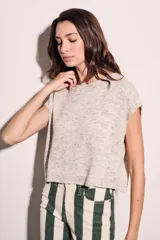 Chaleco de punto color beige con cuello redondo y mangas cortas.