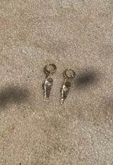 Aros dorados con dije colgante de vidrio color ámbar.