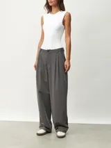 Pantalón gris oscuro de vestir con pinzas, corte amplio y tiro alto.