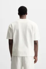Camiseta negra de corte holgado, con cuello redondo y mangas cortas.