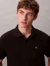 Chomba negra de piqué de algodón, corte clásico, cuello tradicional y tapeta de botones. Logo de Calvin Klein bordado en el pecho.