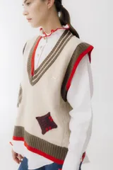 Chaleco de lana color marrón con escote en V, sisa cuadrada y detalles de picas y corazones.