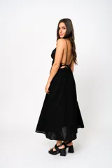 Vestido largo negro con escote en V, tirantes finos y espalda baja. Tiene frunces en la cintura que realzan la silueta.