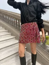Minifalda de lentejuelas con diseño floral en tonos fucsia, rosa y dorado.