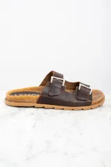 Sandalias de cuero marrón con doble tira ajustable con hebilla metálica.
