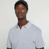 Remera polo celeste de piqué de algodón, corte clásico, con cuello y mangas con ribete blanco.