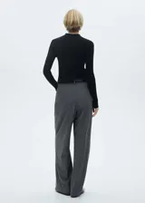 Jersey negro de punto fino con cuello camisero, diseño entallado y botones decorativos.