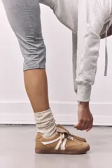 Championes de cuero con estampado animal print, detalles en negro y suela marrón.