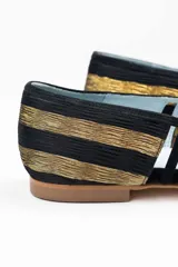 Bailarinas negras con pulsera, diseño bicolor que combina negro, dorado y transparencias. Fabricadas en España con materiales de alta calidad. Diseño con múltiples calados y rejilla transparente negra en la parte delantera. Punta y talón de seda plisada en oro y negro. Interior de piel y suela de cuero. Incluye cuña interna de 1,5cm y plantillas intercambiables de piel y lana.