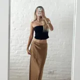 Pollera larga de seda color caramelo con elástico en la cintura.