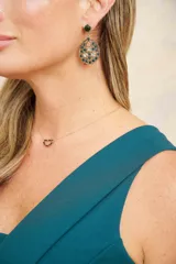 Aros colgantes ovalados con incrustaciones de piedras verdes y plateadas.