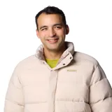 Campera puffer reversible color beige con cuello alto y cierre frontal con botones a presión. Tiene bolsillos laterales con doble entrada y puños elásticos.