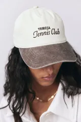 Gorra de béisbol color crema con visera marrón y bordado frontal con la leyenda "Tribeca Tennis Club".