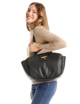 Cartera negra de cuero sintético con textura granulada, asas superiores y solapa frontal con broche metálico dorado en forma de "T".