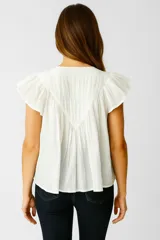 Blusa blanca de algodón con frunces, corte ancho y cuello en V, con mangas cortas con volados.