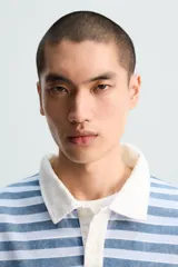 Polo de hombre a rayas horizontales azules y blancas, con cuello clásico blanco y corte relaxed fit.