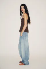 Zapato destalonado plano color marrón, con efecto satinado, detalle de fruncidos en la punta, lazo con perla y tira elástica en el empeine.