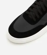 Championes casuales de hombre confeccionados en PU negro con recortes y suela bold blanca.