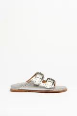 Sandalias plateadas de cuero vacuno con doble tira y hebillas metálicas.