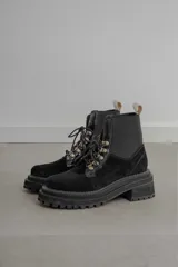 Borcego de gamuza color verde militar con elásticos laterales negros, cordones negros y suela de goma negra con plataforma.