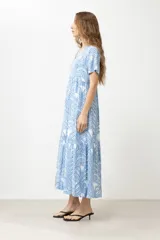Maxi vestido celeste con estampado de hojas blancas y azules, de corte suelto y manga corta.