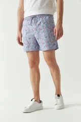 Short de baño celeste con estampado de hojas, cintura elástica con cordón ajustable, dos bolsillos laterales y uno trasero.