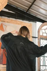 Camisa blanca de lino con bordados dorados de árboles, corte recto, cuello camisero y mangas largas con puños abotonados.