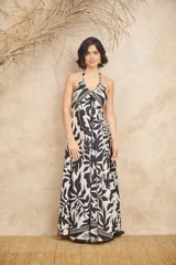 Vestido largo con estampado floral en blanco y negro, escote halter y corte fluido.