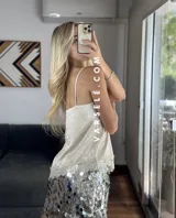 Musculosa lencera blanca con encaje, escote pico y tirantes finos. Bajo asimétrico.