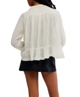 Blusa color crema de voile semitransparente con cuello y mangas largas con ribete de encaje, y botones en el frente.