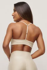 Top deportivo color beige con breteles finos y espalda deportiva.