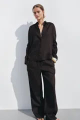 Pantalón palazzo color ladrillo confeccionado en lino 100%, de tiro medio con cintura ajustable con cordones, bolsillos laterales ocultos en costura y pierna ancha.