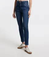 Pantalón skinny de jeans azul oscuro, con trabillas en la cintura, cierre de botón y cremallera, bolsillos delanteros y traseros con recortes diagonales.