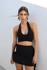 Top corto azul con brillos, escote halter y espalda descubierta.