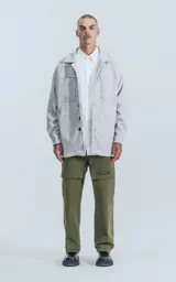 Chaqueta gris melange de paño con cuello clásico, cierre frontal con botones negros, dos bolsillos de parche en el pecho y dos bolsillos laterales.