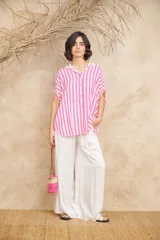 Camisa amplia de manga corta con rayas verticales celestes y blancas, con cuello clásico y terminaciones en rojo.