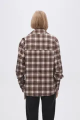 Camisa a cuadros marrón y beige de manga larga con cuello clásico y bolsillo en el pecho.