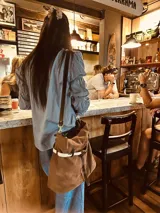 Bolso marrón de cuero gamuzado con correa bandolera de cuero marrón y detalle de cuero con estampado animal print.