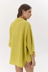 Camisa marrón de lino con mangas 3/4, cuello clásico y cierre con botones.