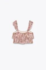 Top corto de bambula color rosa con estampado paisley en tonos dorados. Tiene escote recto, tirantes finos con volantes y cierre en la espalda con botones forrados.