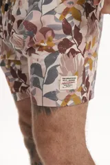 Short de baño color verde oscuro o negro con diseño texturizado o estampado sutil en franjas horizontales y detalles perforados. Posee cordón de ajuste trenzado en la cintura.