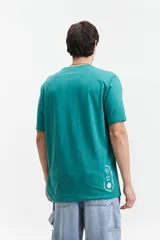 Remera verde con estampado de planta de marihuana y texto en color celeste.