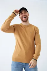 Sweater color mostaza de algodón, con cuello redondo y logo bordado en el pecho.